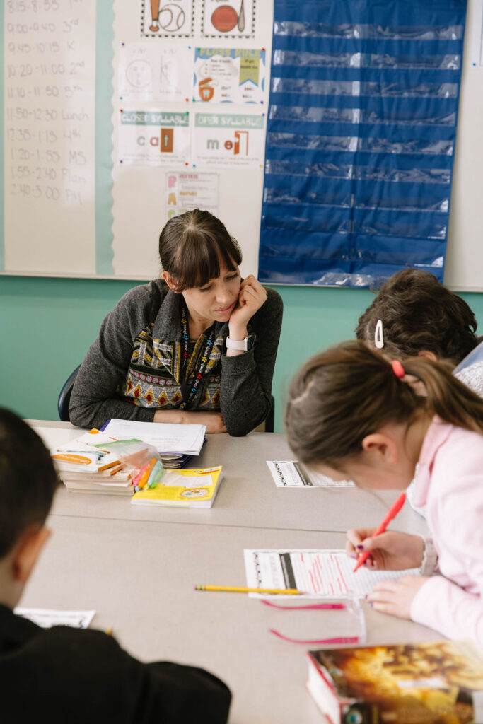 0O5A9651-Enhanced-NR an elementary teacher helping a group of students with homework